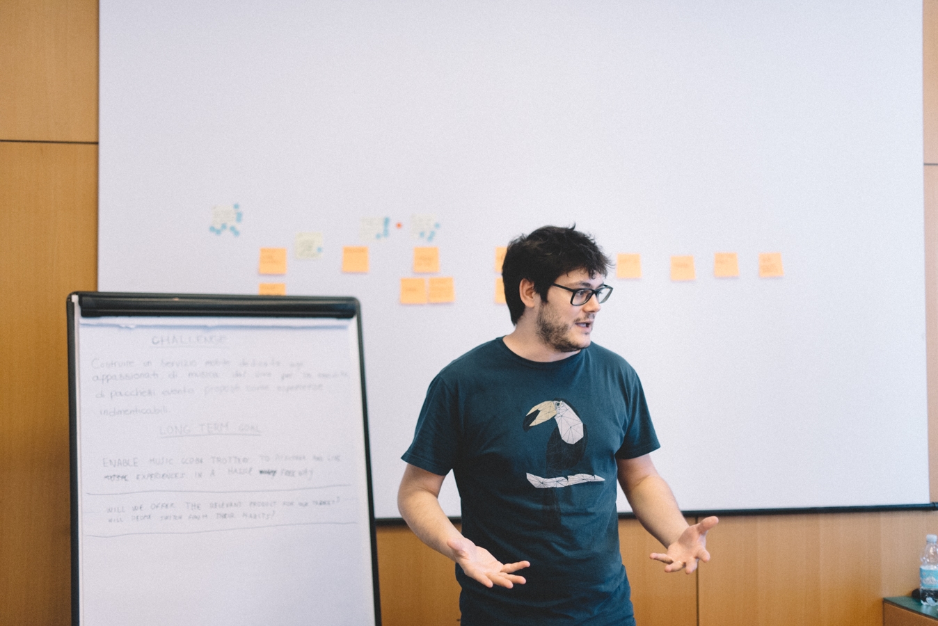 A Moze designer presents the outcomes of a co-design session in front of a wall of notes.